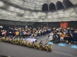 fotografia colorida de auditório lotado de participantes